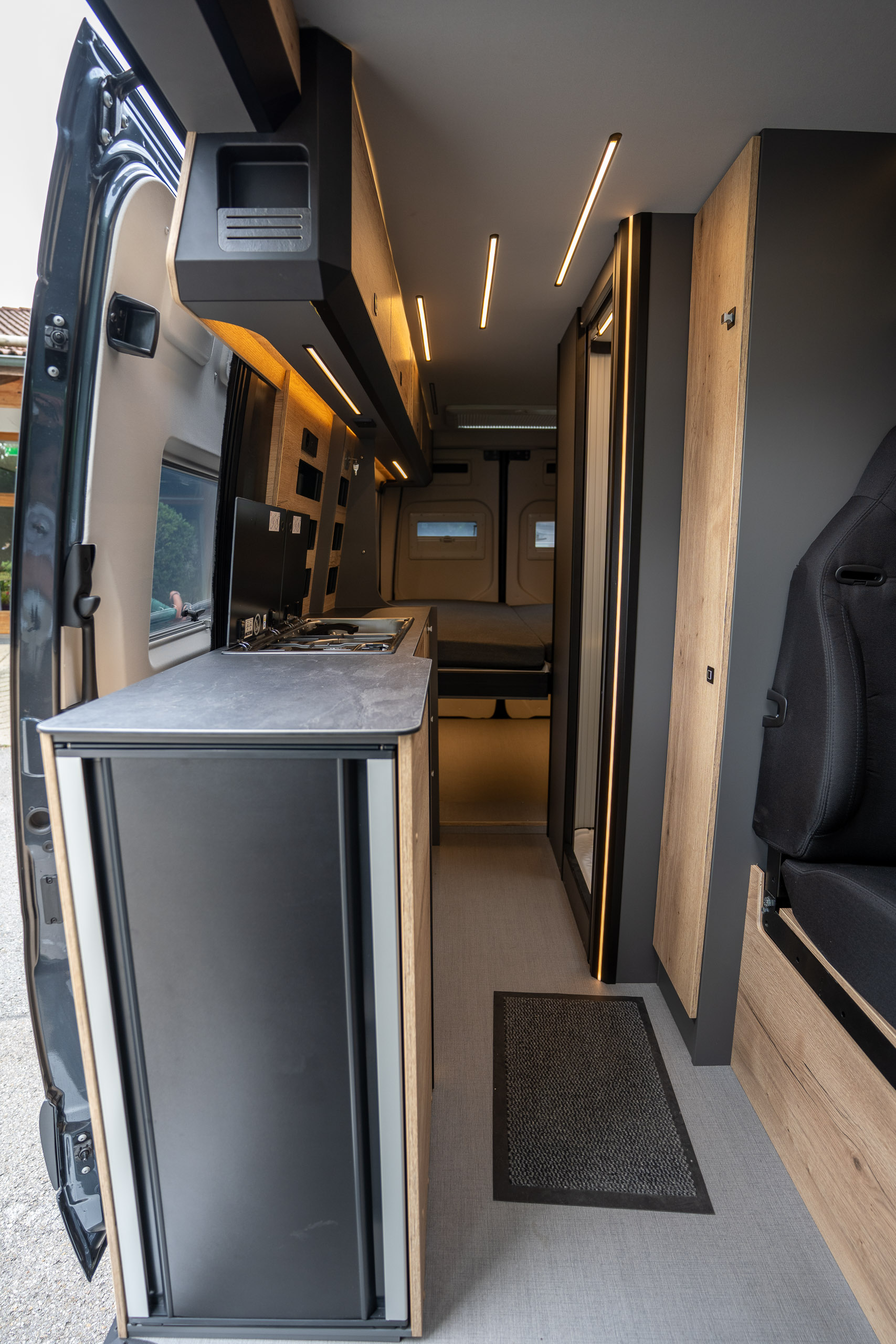 Küche im Pössl Roadstar XL Evo mit zweigeteilter Glasabdeckung und innenliegendem Wasserhahn