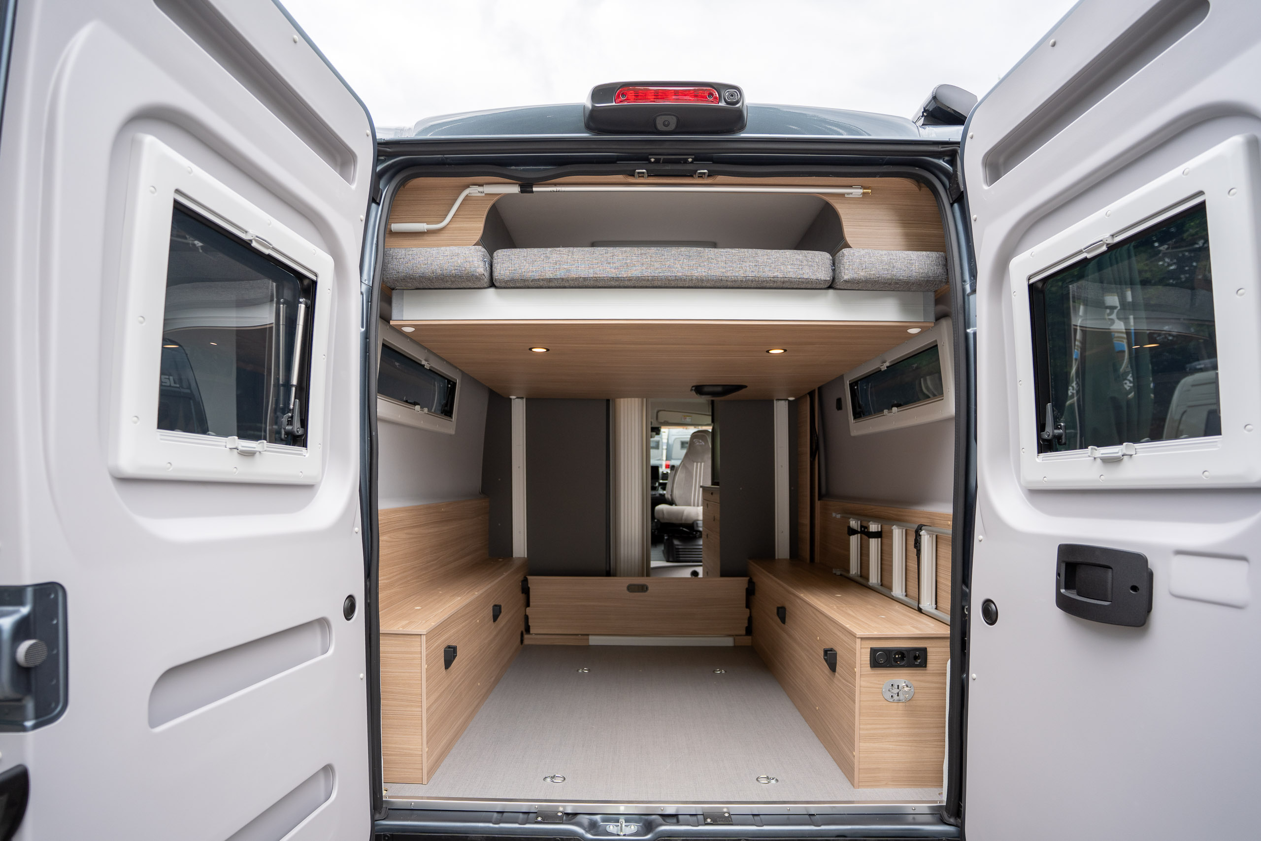 Summit Shine 640 R Evo mit geöffneten Hecktüren: riesige Heckgarage unter dem elektrischen Hubbett, seitlich der Schrank mit Leiterfunktion